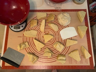 mat on table covered in cut pieces of dough, a pile of cubierta, and baking tools