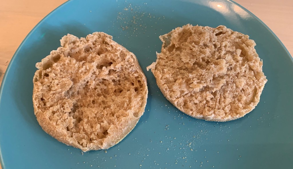 English muffin split open on a blue plate.