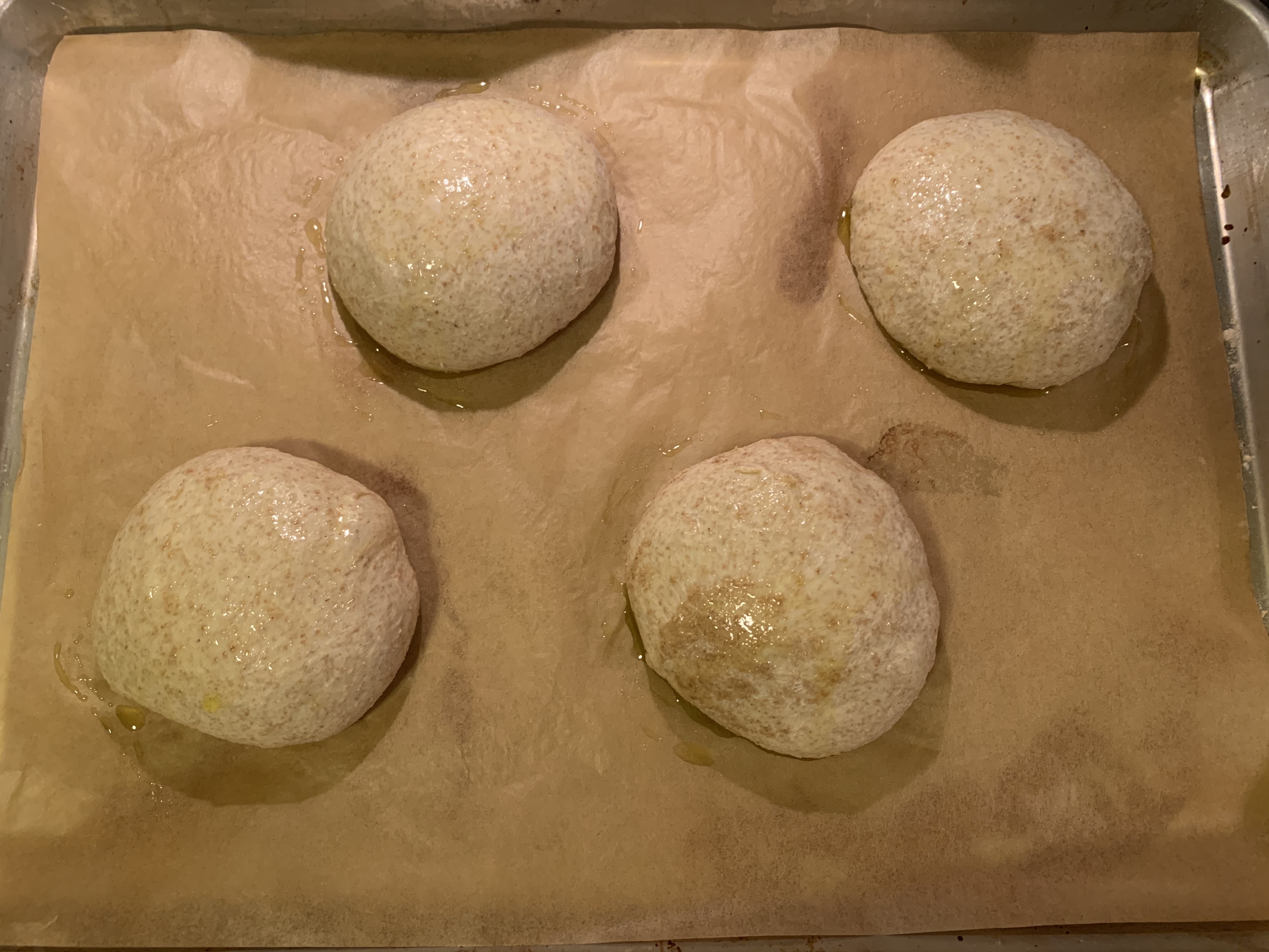 four balls of dough on parchment paper